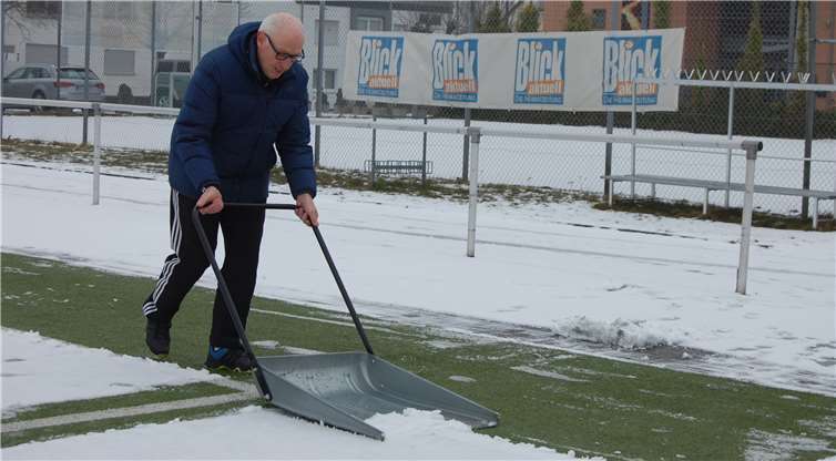 Selbst ist der Mann: Hermann Krings befreit mit einem XXL-Schneeschieber die Torauslinie vom Schnee. -SK-