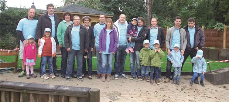 Sie freuen sich zusammen über die neue Spielecke im Außenbereich der Kita St. Genovefa: Kinder und Eltern mit RWE-Kommunalbetreuerin Beatrix Ziegler und dem Projektpaten Matthias Derner in Mendig. privat