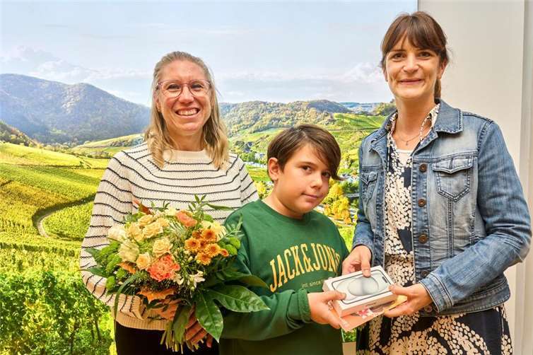 Sie freut sich über ihren Gewinn: Ivonne Weber-Gras und ihr Sohn aus Lahnstein (links) halten ihr brandneues iPhone 15 in den Händen, das ihnen von Annika Hammes (evm) überreicht wurde.Foto: Sascha Ditscher/evm