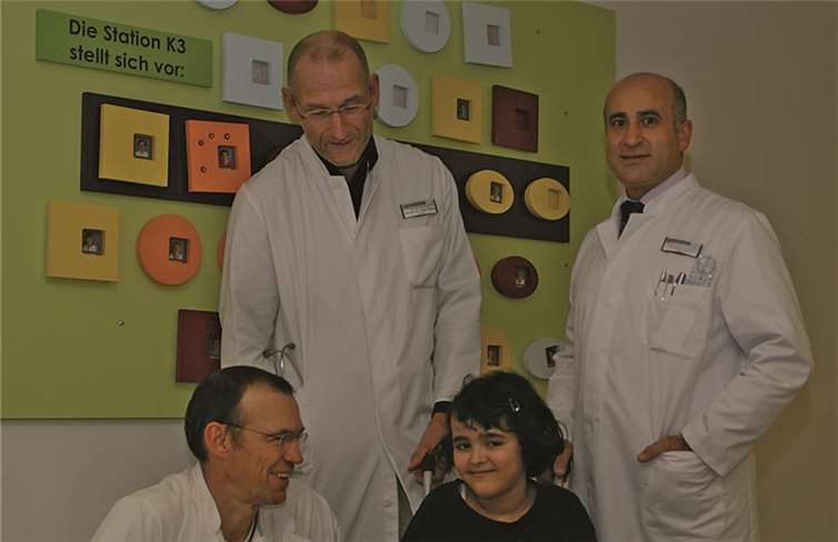 Sie kann schon wieder etwas lachen - die zehnjährige Bibi, die wieder erste Schritte machen kann. Mit ihr freuen sich (von links) Dr. Bernhard Rosenkranz, Dr. Thomas Nüßlein und Dr. Hüseyin Senyurt.privat