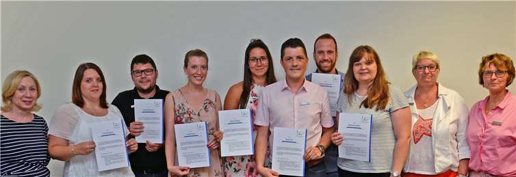 Sieben junge Verwaltungskräfte halten ihre Zertifikate nach zweijährigem Schulungsprogramm in den Händen. Foto: Kreisverwaltung