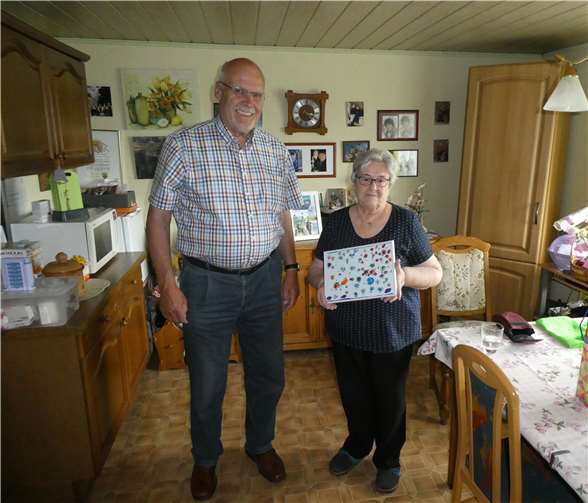 Siegfried Schutzeich überreichte Hannelore Ehlscheid zu ihrem 80. Geburtstag das Bild mit Marienkäfern und Sommerkäfern einer dreijährigen Künstlerin. Foto: privat