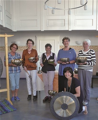 Sigrid Hergarten (kniend) mit den Teilnehmerinnen inmitten der Klangschalen und Gongs. privat