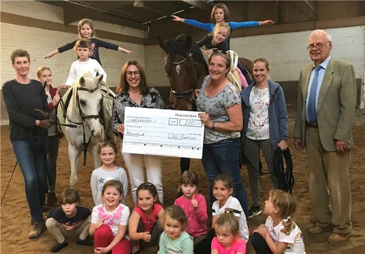 Silke Josten-Schneider (Mitte) und Claus Wehage (rechts) überreichen den Scheck. privat