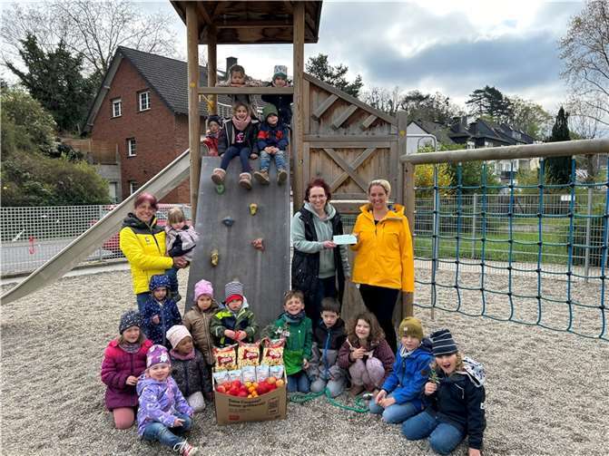 Simone Dietzler, Geschäftsführerin des REWE-Marktes in Lahnstein, überreicht den Kindern und Mitarbeiterinnen der Kita Rambazamba einen großen Präsentkorb mit gesunden Leckereien sowie einen symbolischen Scheck der Pfandaktion. Foto: Eva Dreiser / Stadtverwaltung Lahnstein