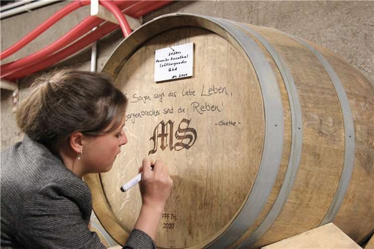 Sina Erdrich signiert im Keller des Recher Weingutes Max Schell ein Barriquefass. Es ist eines der wenigen Fässer, die die Flut unbeschadet überstanden haben.