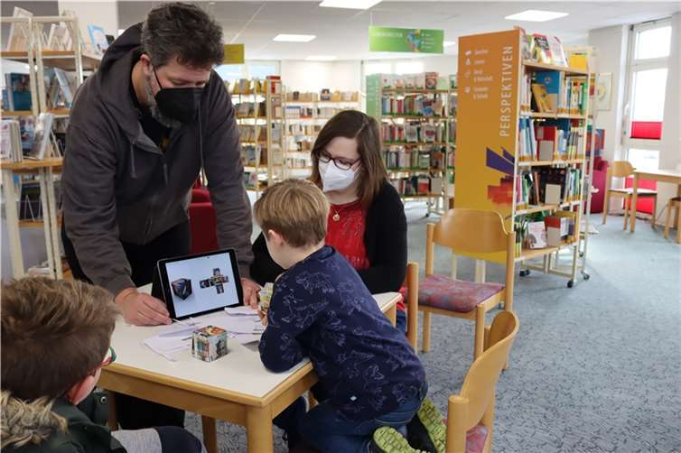 So kommt der Würfel vom Tablet auf den Tisch. Beim Medientraining in der Stadtbibliothek übten die Vorschulkinder der Kita Himmelfeld sowohl die Handhabung von Tablets als auch den Umgang mit Schere und Papier. Das Training haben Daniel Zils von medien+bildung.com und Carina Senko von der Stadtbibliothek geleitet.Foto: Stadt Montabaur