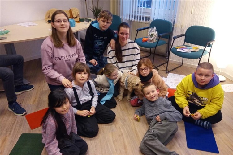 Sophie Weber mit ihrem Therapiebegleithund Lou und den stolzen Kindern aus dem Hort Pusteblume.