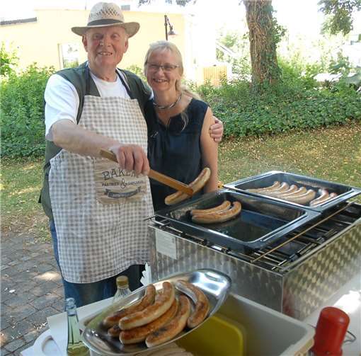 Spaß muss sein: Der Helfer an der Würstchenpfanne lässtaber auch beim Scherzen sein Grillgut nicht aus den Augen.