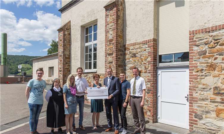 Spende für die neue Verdunkelungsanlage in der Aula des Gymnasiums Calvarienberg: Der Direktor des Regionalmarktes AhrBrohltal der RheinAhrEifel eG Thomas Theisen (3. von rechts) und der Leiter der Filiale in Ahrweiler, Christian van-de-Loo (rechts), überreichen einen Spendenscheck in Höhe von 6.356 Euro an die Schulleitung am Calvarienberg, Dr. Annette Gies (3. von links), Schwester Roswitha Maria Schmitz (2. von links), Realschulkonrektor Christian Bernard (4. von links) sowie die Projektinitiatorin Christina Weber und Schüler. Privat