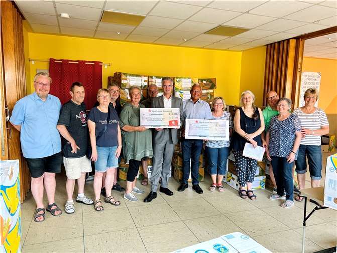 Spendenübergabe an die „Freu(n)de für Belarus“ in Neuwied-Irlich: Christel (5. v. li.) und Hans-Peter Weißenfels (4. v. li.) sowie zahlreiche Helferinnen und Helfer freuen sich über die Spendenschecks von Sparkassenvorstand Thomas Paffenholz und Landrat Achim Hallerbach. Foto: Martin Boden / Kreisverwaltung Neuwied