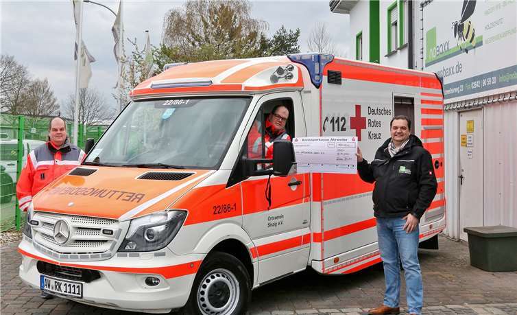 Spendenübergabe in Zeiten der Coronakrise mit Sicherheitsabstand und ohne Handschlag: Roman Förster (re.) überreicht eine Spende in Höhe von 500 Euro für die Beschaffung eines neuen Beatmungsgerätes für den Sinziger DRK-Rettungswagen an Martin Hengsberg (re.), zweiter Vorsitzender im DRK-Ortsverein Sinzig e.V., und seinen Bruder Marco (li.), Bereitschaftsleiter der Sinziger Rotkreuzler. Foto: Thorsten Trütgen