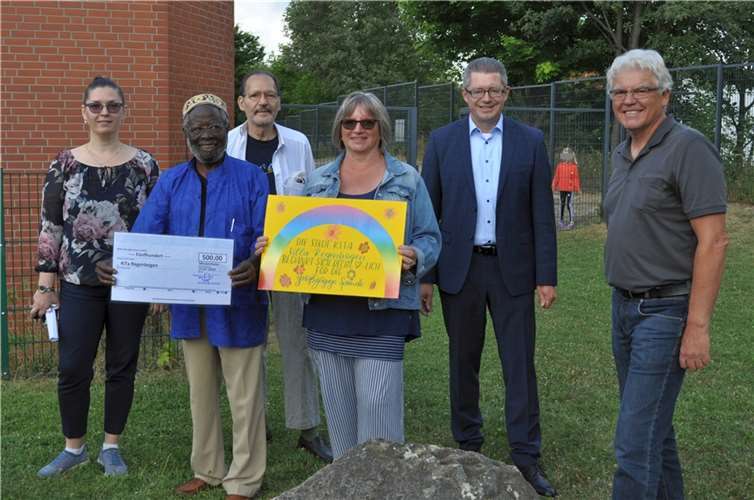 Spendenübergabe, von links: Jugendhilfe-Leiterin Anna Sitner, Künstler Mamadou Diakhaté, Kunstsammler Marcel Bouziri, Kita-Leiterin Alexandra Dietz, der Erste Beigeordnete Hans Dieter Wirtz und Klaus Weiler, der sich eines der Bilder sichern und damit die Aktion unterstützen konnte.  Foto: Stadt Meckenheim