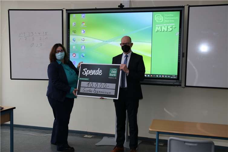 Spendenübergabe vor modernem Digitalboard: Christa Habscheid, Leiterin des Goethe-Gymnasiums Bad Ems, freut sich über eine 10.000-Euro-Spende der PSD Bank Koblenz, überreicht von Bernd Schittler, dem Vorstandsvorsitzenden der Bank. Von dem Geld konnten digitale Präsentationsflächen und Videokonferenzsysteme angeschafft werden. Quelle: PSD Bank