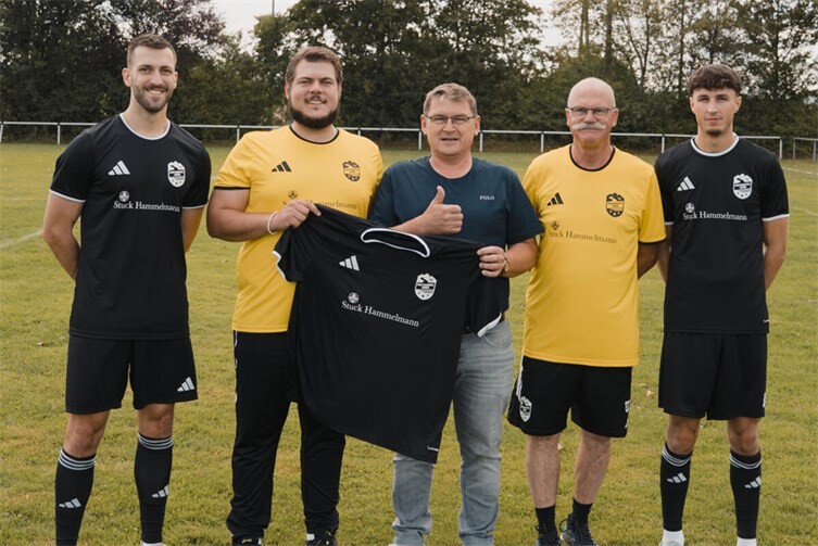 Spieler der SG Vinxtbachtal Brohl II und Wolfgang Hammelmann  präsentieren den neuen Trikotsatz.