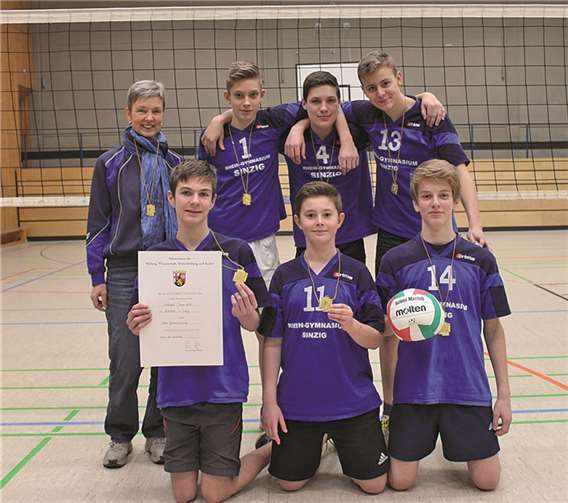 Sportlehrerin Monika Michno (l.) und die Volleyballer des Rhein-Gymnasiums freuen sich über den erneuten Sieg im Landeswettbewerb von „Jugend trainiert für Olympia“. privat