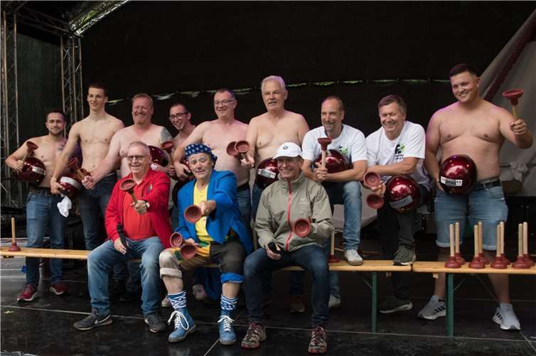 Sportlich ging es auf der Bühne zu, als neun Herren mit freiem Oberkörper die Bühne betraten. Gerhard Donie aus Meckenheim, Weltmeister im „Pömpel-Dart“, wollte seinen eigenen Rekord brechen. Dabei galt es, die Pömpel, die als Reinigungsgeräte für Abflüsse bekannt sind, auf den Rücken von Männern zu werfen, die mindestens drei Sekunden daran haften bleiben mussten. Fotos: EICH