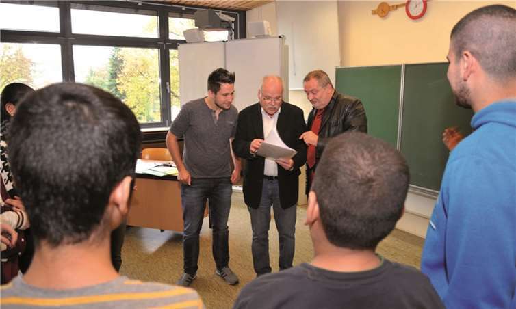 Sprachförderkraft Georg Münz (links), VHS-Geschäftsführer Günter von Blohn (Mitte) und Schulleiter Martin Leupold übereichen den Schülerinnen und Schülern, die an dem Feriensprachkurs teilgenommen haben, ihre Zertifikate. Stadt Andernach/Maurer