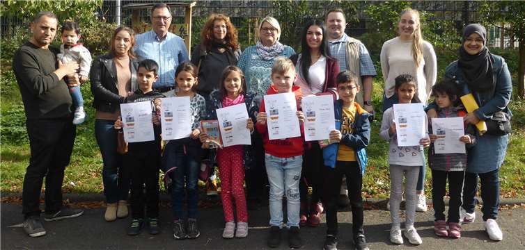 Sprachförderkraft Lisa Zinndorf, die Leitungen der katholischen Kita St. Matthias, Thomas Bläsche und des Herrnhuter Kinderhauses, Pamela Brings sowie Mitarbeiter der Abteilung Kindertagesstätten und Kindertagespflege, Fachbereichsleiter Karl Oster und Petra Marks , gemeinsam mit Kindern und Eltern. Foto: Stadt Neuwied