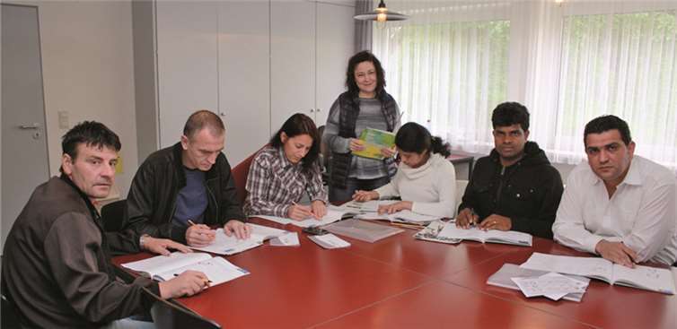 Sprachkursteilnehmer im Rathaus mit ihrer Dozentin. Margit Märtens