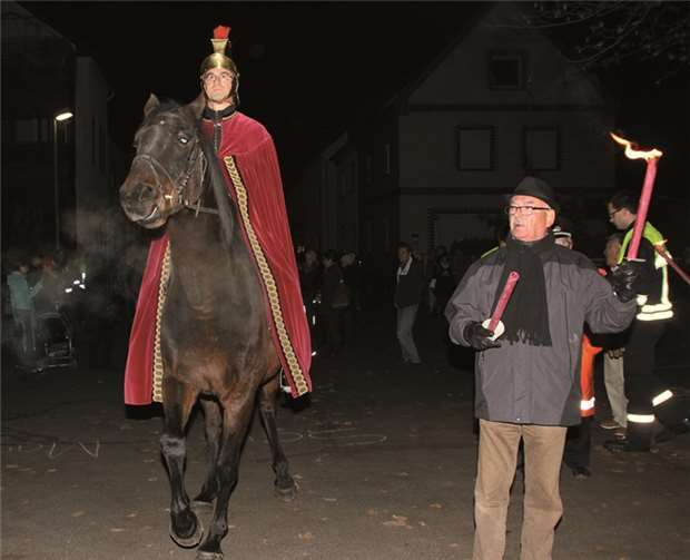 St. Martin hoch zu Ross in Bad Neuenahr, eingerahmt von den Fackelträgern der Bürgergesellschaft Hemmessen (links Schultes Hans-Werner Helmrich).