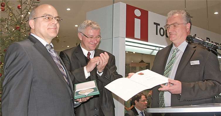 Staatssekretär Uwe Hüser (r.) überreichte Jürgen Czielinski (l.) die Wirtschaftsmedaille des Landes,Oberbürgermeister Hofmann-Göttig (Mitte) applaudiert.uko