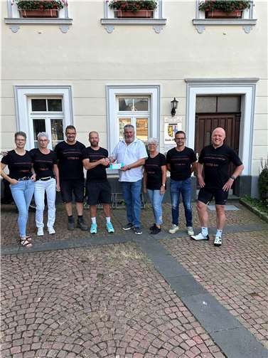 Stadtbürgermeister Achim Grün überreicht den Siegerscheck an Christoph Kettner und sein Team „Power durch Obst und Gemüse“.  Foto: Stefan Pauly/VG-Verwaltung Mendig