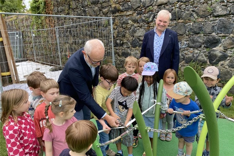 Stadtbürgermeister Alfons Mußhoff (l.) zerschneidet das Band zusammen mit den Kindern. Karsten Fehr (r.), Bürgermeister der Verbandsgemeinde Unkel, schaut dem Treiben zu.