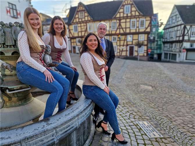 Stadtbürgermeister Dr. Hans Georg Faust präsentierte am Stadtbrunnen das Linzer Weintrio 2024/2025 (sitzend, v.r.): Weinkönigin Antonia Izabela Wegner mit ihren Weinprinzessinnen Nina Engels-Riegel und Sophie Stöcker.  Foto: AWi