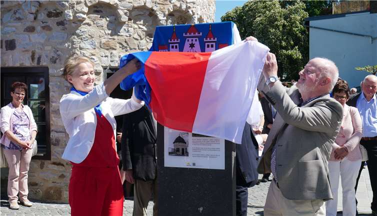 Stadtbürgermeisterin Gabi Wieland und Altbürgermeister Paul Possel-Dölkenenthüllen feierlich die neue Stehle, die über die Historie des Ortes informiert. Fotos: GBA