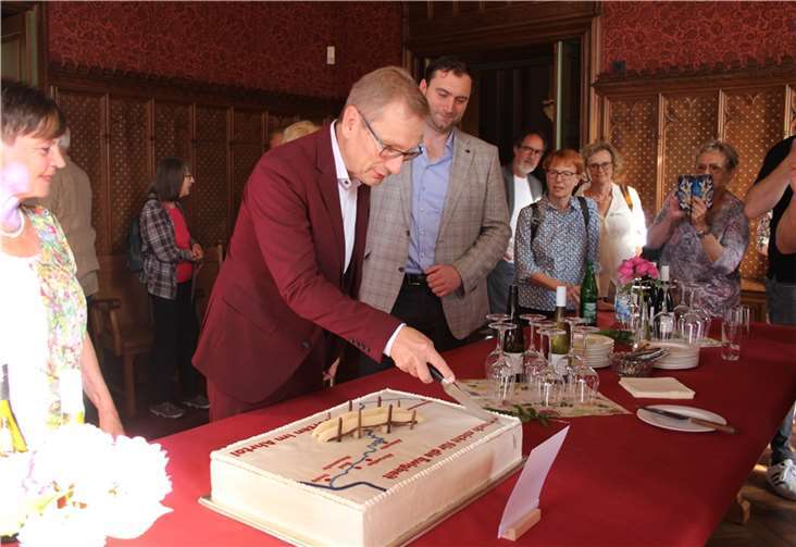 Stadtchef Geron schneidet die Brückentorte an.