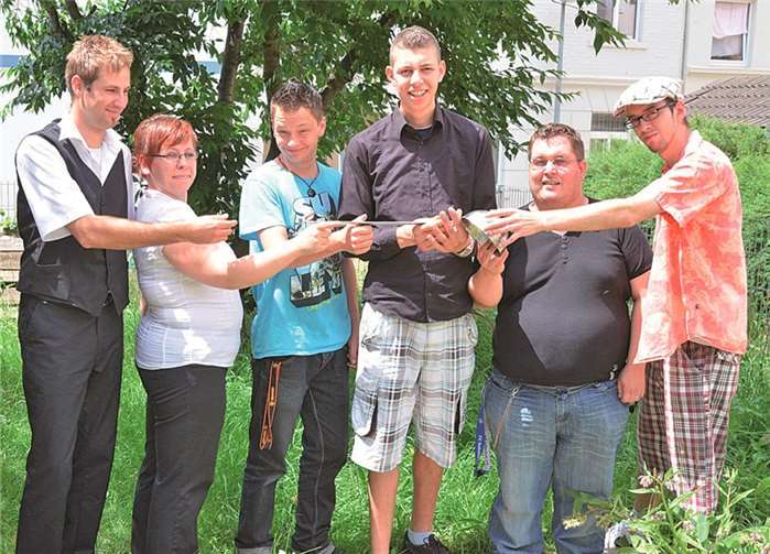 Staffelübergabe: Absolventen der gerade abgeschlossenen Qualifizierungsmaßnahme übergeben einen Kochlöffel als „symbolischen Staffelstab“ an die neuen Teilnehmer von „MYK4international“. privat