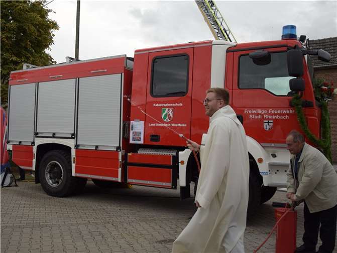 Standesgemäß segnete Pastoralreferent Simon Beranek das neue Löschgruppenfahrzeug KatS der Löschgruppe Niederdrees mit Weihwasser aus der Kübelspritze.  Foto: Feuerwehr Rheinbach.