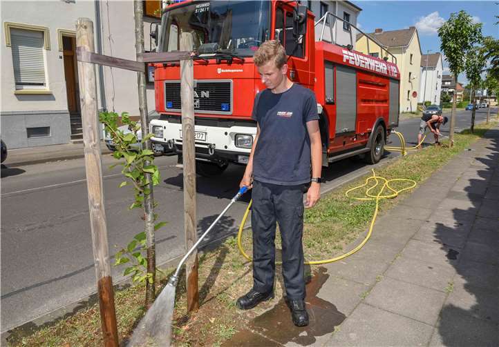 Starke Unterstützung durch die Floriansjünger: Philipp Benner und Achim Schneider (hinten) von der Feuerwehr Neuwied helfen beim Gießen die Bäume. Das muss behutsam gemacht werden, da die Oberfläche extrem trocken und hart ist.privat