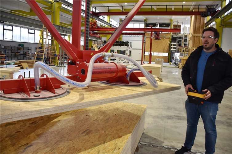 Statt durch Muskelkraft werden bei plan74 Vakuumsauger für das Heben der Holzplatten eingesetzt Elektriker Benjamin Lukas testet hier die neue Software.