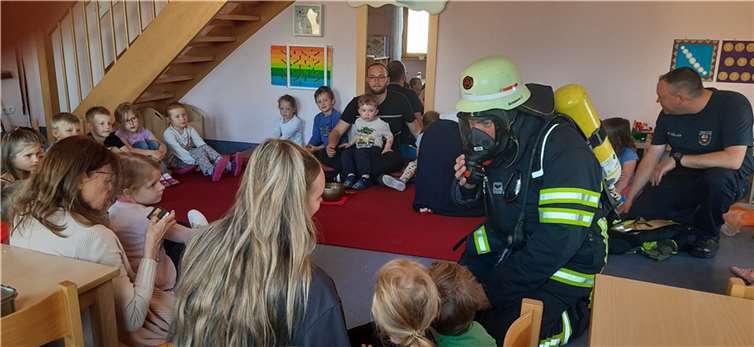 Stefan Müller und Carsten Sauerborn, von der Löschgruppe Trimbs waren mit der Ausrüstung eines Atemschutzträgers angereist, um den Kindern die Angst zunehmen.