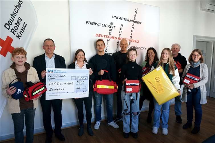 Stefan Schulz (2.v.l.) bei der Spendenübergabe an Frau Köhler (3.v.l.) sowie Vertreter*innen und Schüler*innen der am Schulsanitätsdienst beteiligten Schulen. Quelle: DRK Kreisverband Neuwied