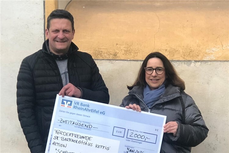 Stefan Windheuser überreicht Petra Gies-Moskopp, FörderFreunde St. Bartholomäus Kettig, den symbolischen Spendenscheck.