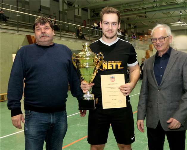 Stellvertretend für die Mannschaft bekommt Christian Baur aus der Hand von Gerd Stappen (li) und Beigeordneten Udo Seifen den Siegerpokal.