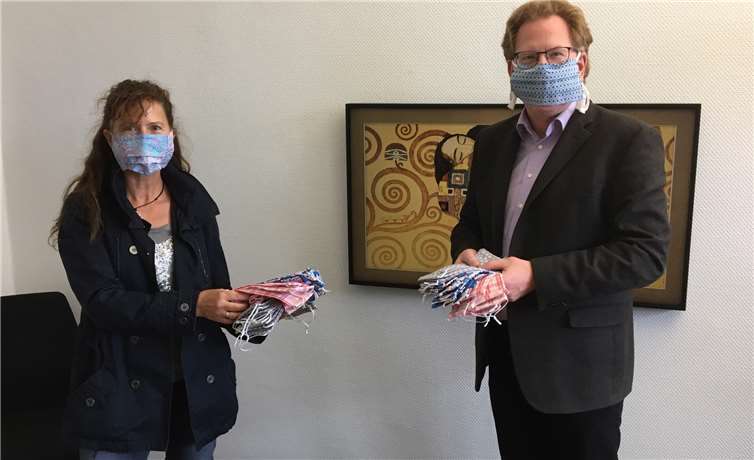 Stellvertretend für die Remagener Schulen nimmt Marcus Wald (re.), Schulleiter der IGS Remagen, die Masken von Silke Bisenius (li.) entgegen.Quelle: IGS Remagen