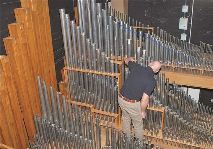 Stephan Mayer im Wirrwarr der Orgelpfeifen beim Ausbau einer Pfeife, doch er hat den Überblick.