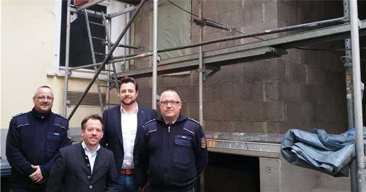 Stephan Wefelscheid und Lennart Siefert im Kreis von Polizisten der Polizeiinspektion St. Goarshausen. Im Hintergrund zu sehen ist der Anbau der barrierefreien Toilettenanlage.