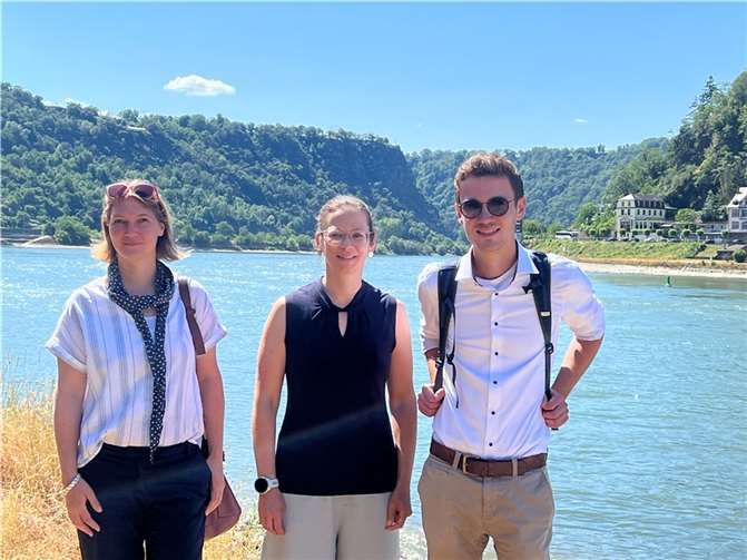 Stephanie Dirks (links), wissenschaftliche Mitarbeiterin des Projektbüros Mühlsteinrevier RheinEifel, Nadya König-Lehrmann, Geschäftsführerin des Zweckverbands „Welterbe Oberes Mittelrheintal“, sowie Projektleiter Dr. des. Nicolas Junglas vor dem berühmten Loreleyfelsen.  Foto: Projetbüro Mühlsteinrevier RheinEifel