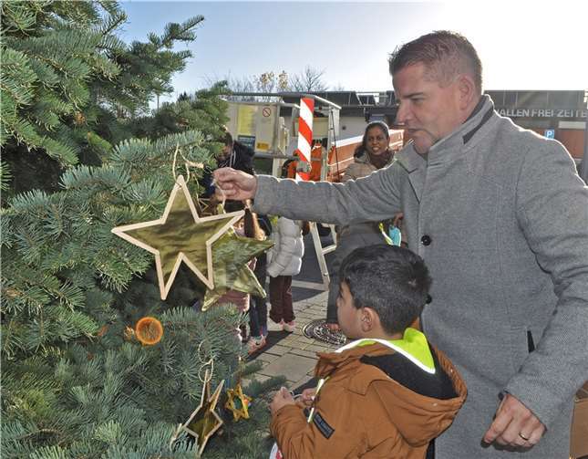 Sterne und anderen Weihnachtsschmuck hängten Bürgermeister Holger Jung und die Vorschulkinder der städtischen Kita Konfetti gemeinsam auf. Foto: Stadt Meckenheim