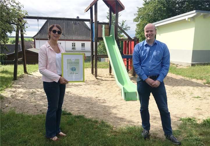 Stiftungsbotschafter Philipp Deutsch übergibt die symbolische Spendenurkunde an Gisela Nobel, Leiterin der Integrativen Kita Zwergentreff.Quelle: HTZ gGmbH / Zwergentreff