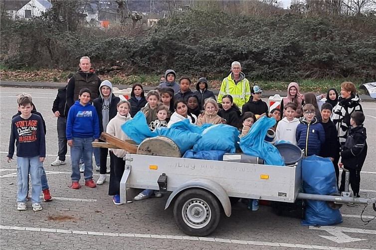 Stolz auf ihre Leistung: Die Schüler*innen der BILA Sinzig präsentieren den prall gefüllten Anhänger mit dem gesammelten Müll aus dem Bildungsviertel entlang der Ahr.