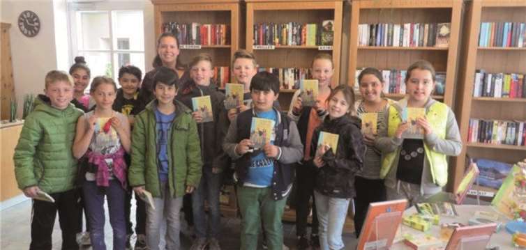 Stolz präsentieren die Kinder der Klasse 4b der Pater-Wald Grundschule ihr soeben erhaltenes Buch zu Welttag des Buches in ihren Händen. privat