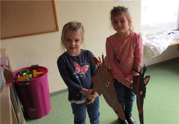 Stolz präsentieren die Kinder die gebastelten Steckenpferde.