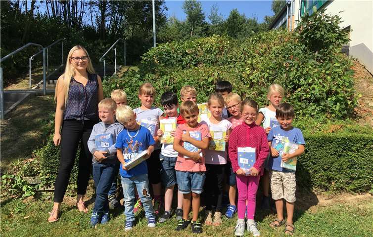 Stolz präsentieren die Kinder ihr Schulhefte-Paket.privat
