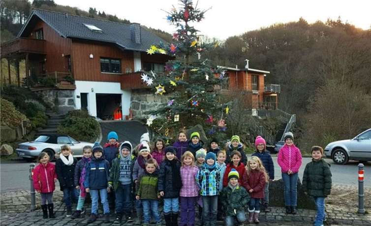 Stolz präsentieren die Kinder ihren schön geschmückten Baum.  Privat